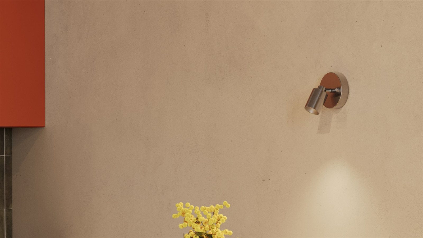 A brushed nickel Shura wall spot light casting a warm beam down a plaster wall